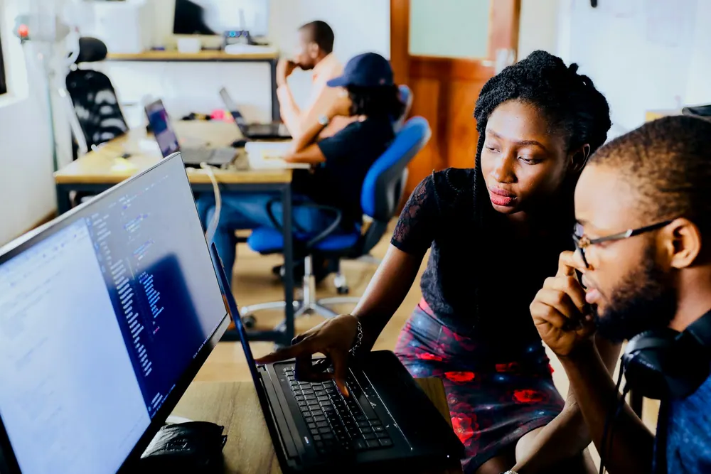 Two developers reviewing work on a computer